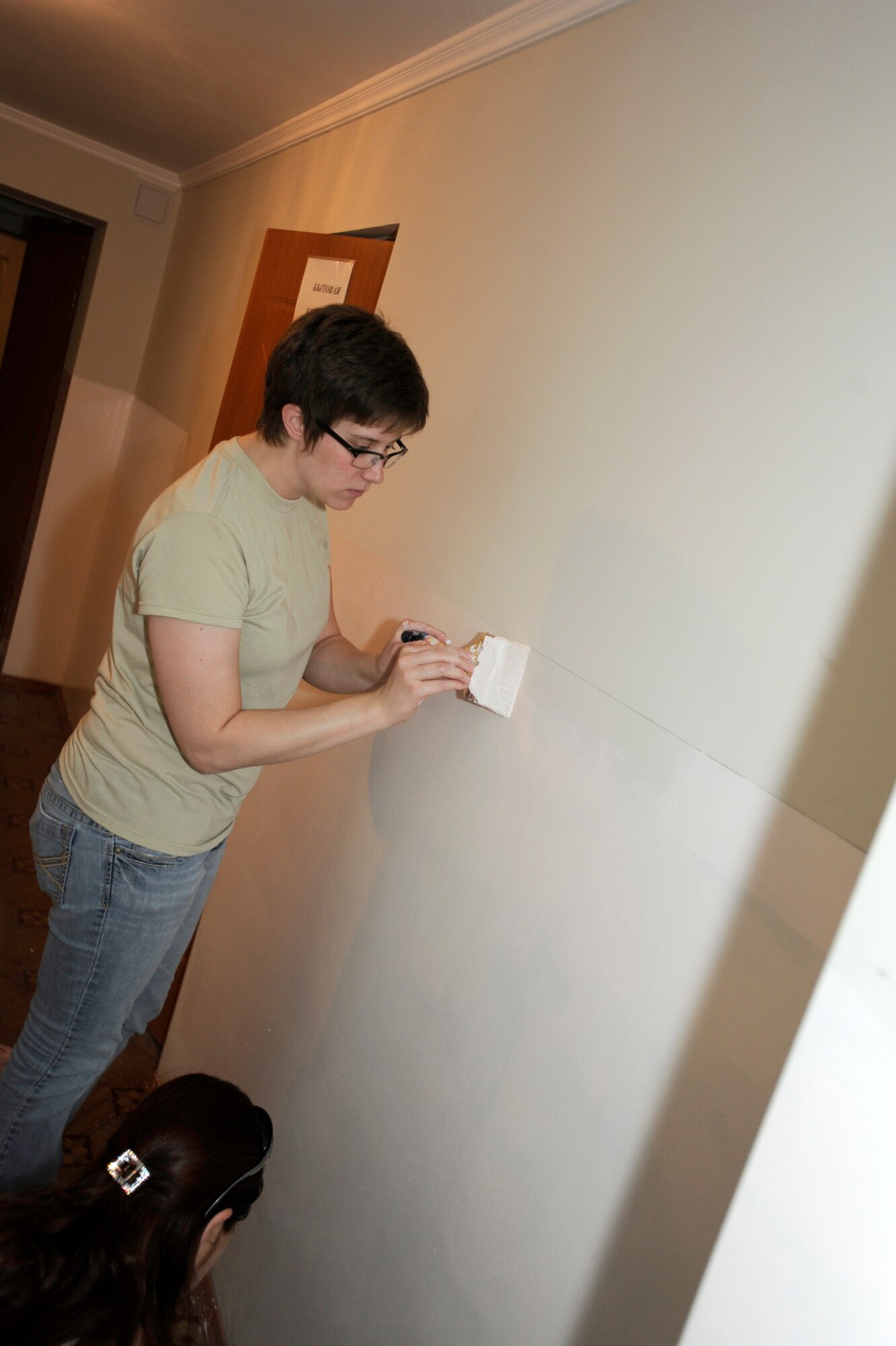 NIZNE-CHUISK VILLAGE, Kyrgyzstan -- Senior Airman Samantha Lewis, 728th Aircraft Maintenance Squadron C-17 supply technician, paints at the Nizne-Chuisk Village school during a Manas Area Benefit Outreach Society visit June 7.  Airman Lewis  deployed here from the 60th Logistics Readiness Squadron at Travis Air Force Base, Calif.  and other MABOS representatives from the Transit Center at Manas visited the "Niz Village" June 7 to help school officials prepare for the upcoming school year.   (U.S. Air Force photo by Master Sgt. Jerome C. Baysmore)