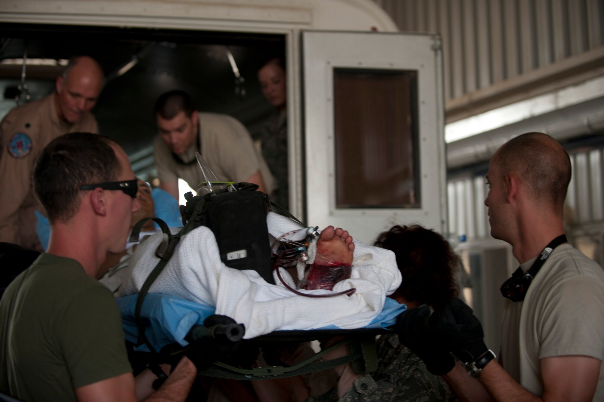 Members from the 451st Expeditionary Aeromedical Evacuation Squadron Detachment 1 Contingency Aeromedical Staging Facility load a wounded Marine onto an ambulance at Camp Bastion, Afghanistan. The CASF team is responsible for taking care of and transporting patients from the staging facility and role hospital to aircraft who are then transported to the next level of medical care. (U.S. Air Force photo by Master Sgt. Adrian Cadiz)