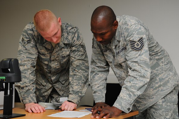 SPANGDAHLEM AIR BASE, Germany – Airman 1st Class Michael Bellury, 52nd Force Support Squadron customer support journeyman, helps Tech. Sgt. Eric Hyler, 52nd Logistics Readiness Squadron customer support supervisor, verify a form before signing it at First Stop here June 6. First Stop is the initial inprocessing center where Airmen and dependants acquire the necessary documents and information to live and work at their new duty station. (U.S.  Air Force photo/Airman 1st Class Dillon Davis