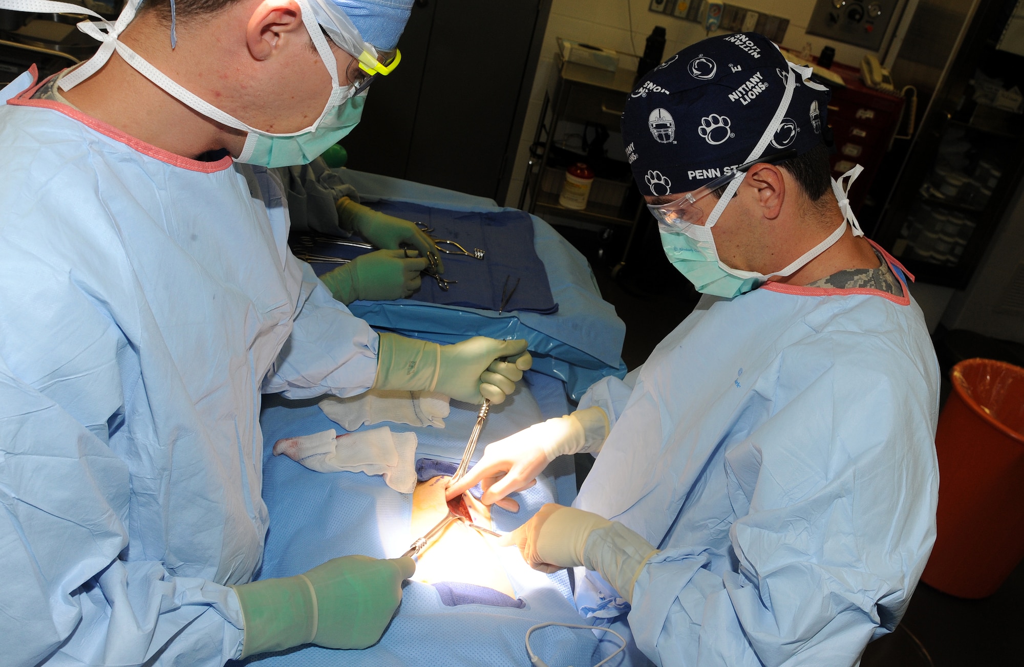 Staff Sgt. Jonathan Kertulis, surgical technician, helps Dr. (Maj) Gustavo Lopes, general surgeon, during an inguinal hernia repair surgery at an undisclosed location in Southwest Asia, May 31. The 379th Expeditionary Medical Group features a mobile forward surgical team which stands ready to respond to contingencies. When not forward deployed, the team performs routine procedures which allow deployed servicemembers to stay in theater for care and recovery. (U.S. Air Force photo/Staff Sgt. Liliana Moreno)                           