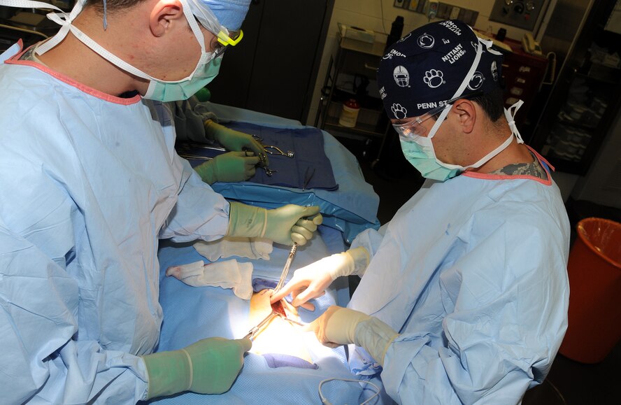 Staff Sgt. Jonathan Kertulis, surgical technician, helps Dr. (Maj) Gustavo Lopes, general surgeon, during an inguinal hernia repair surgery at an undisclosed location in Southwest Asia, May 31. The 379th Expeditionary Medical Group features a mobile forward surgical team which stands ready to respond to contingencies. When not forward deployed, the team performs routine procedures which allow deployed servicemembers to stay in theater for care and recovery. (U.S. Air Force photo/Staff Sgt. Liliana Moreno)                           