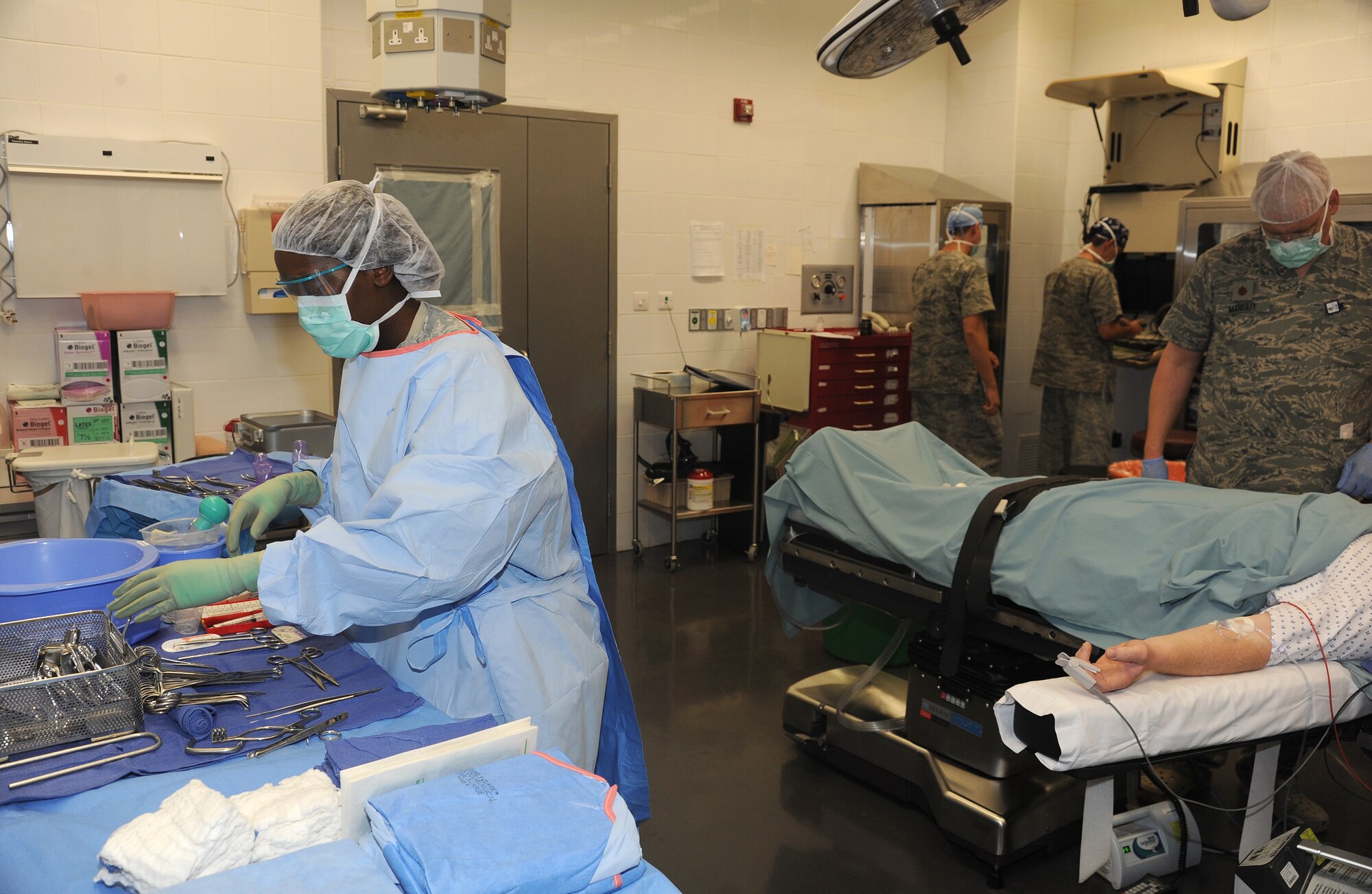 Master Sgt. Shannon Ray, surgical technician, prepares medical equipment while Maj. John Mansuy, operating room nurse, prepares the patient for an inguinal hernia repair surgery at an undisclosed location in Southwest Asia, May 31. (U.S. Air Force photo/Staff Sgt. Liliana Moreno)                          