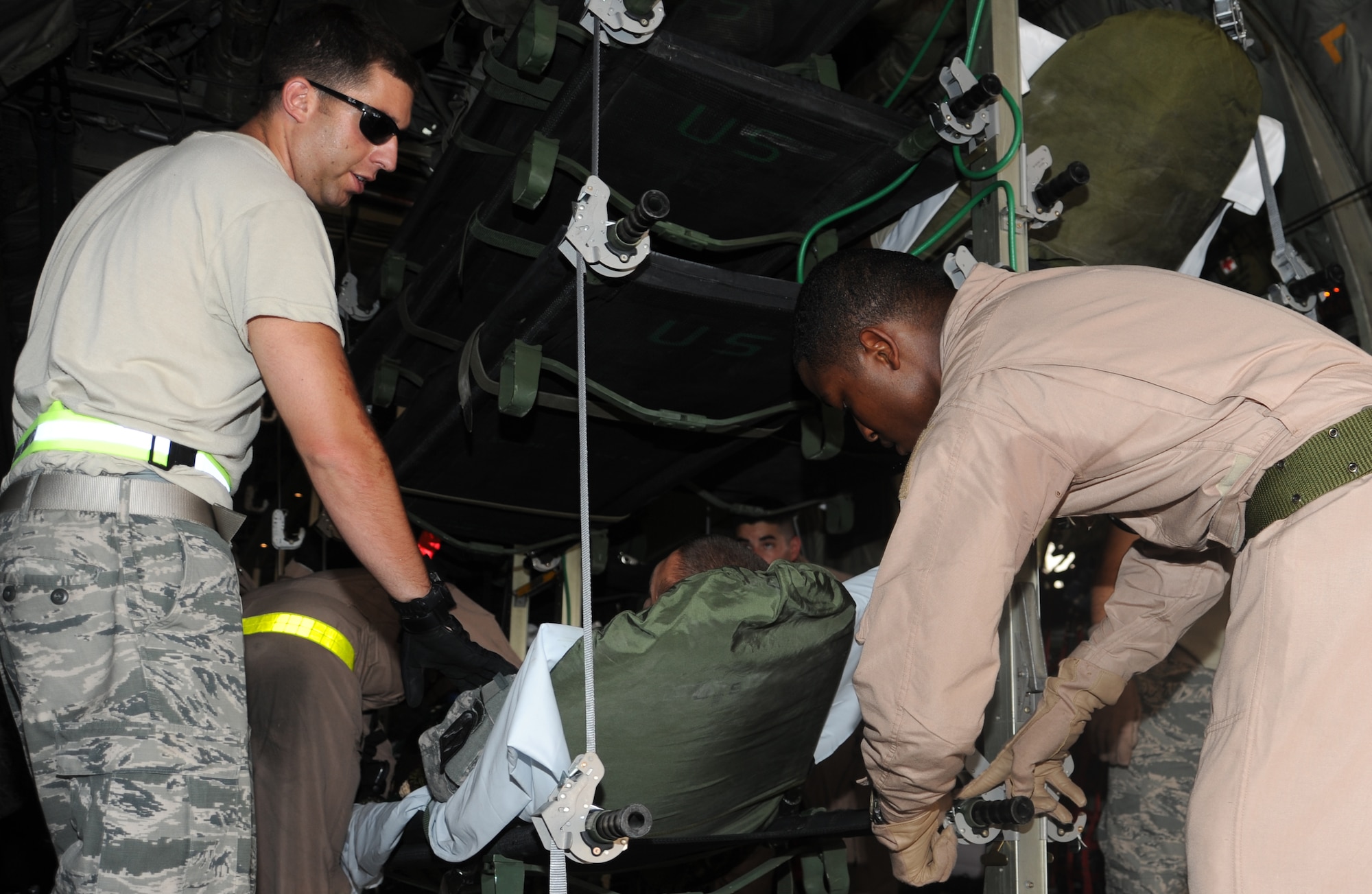 Staff Sgt. Marlon Smith and Senior Airman Daniel Cooper, secure a patient during an aeromedical flight, May 21. The Aeromedical Evacuation Flight transports servicemembers wounded, injured or sick from remote locations to higher level of medical care. (U.S. Air Force photo/ Staff Sgt. Liliana Moreno)                 