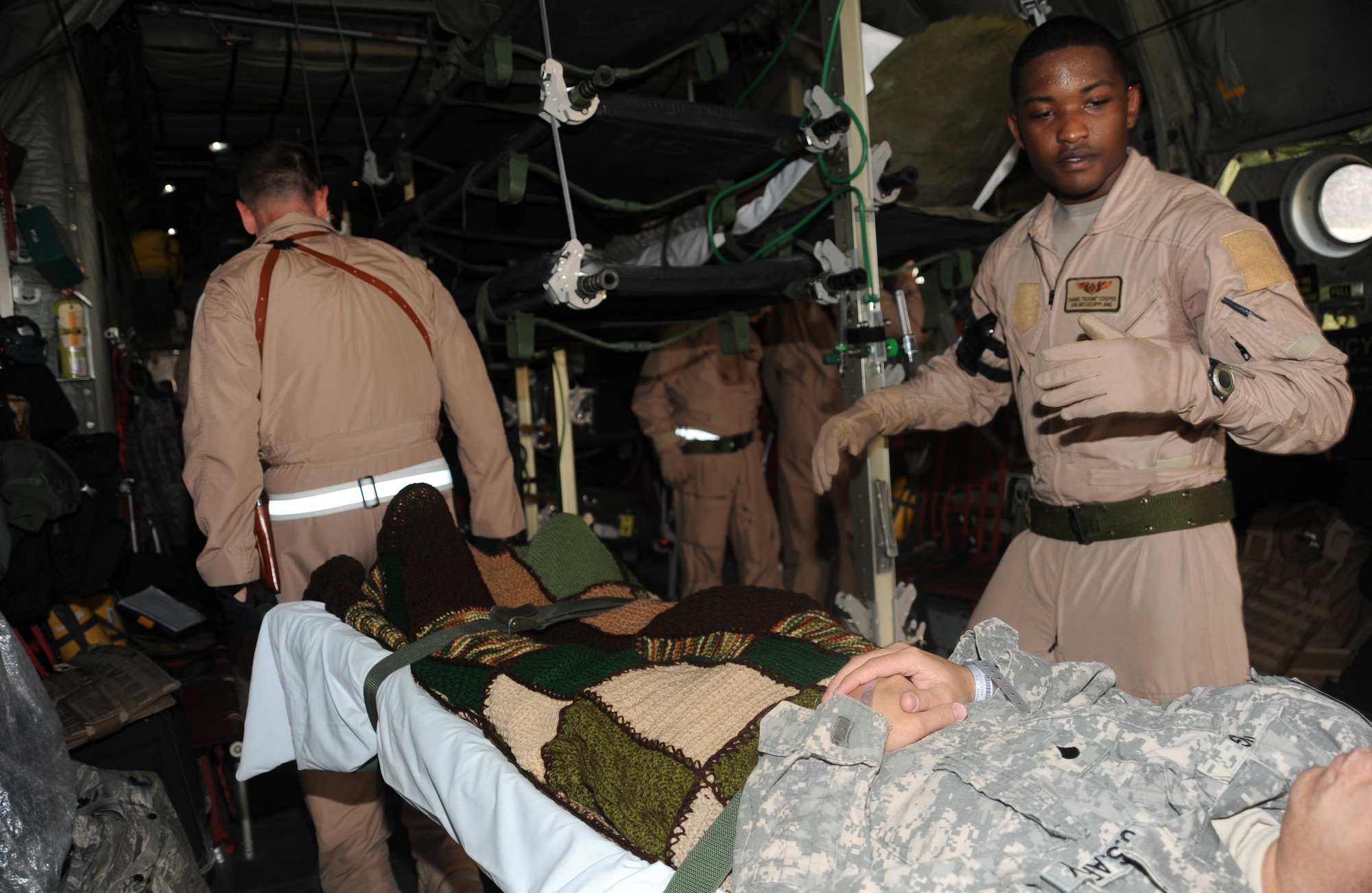 Senior Airman Daniel Cooper, secures a patient during an aeromedical flight, May 21. The Aeromedical Evacuation Flight transports servicemembers wounded, injured or sick from remote locations to higher level of medical care. (U.S. Air Force photo/ Staff Sgt. Liliana Moreno)                                  