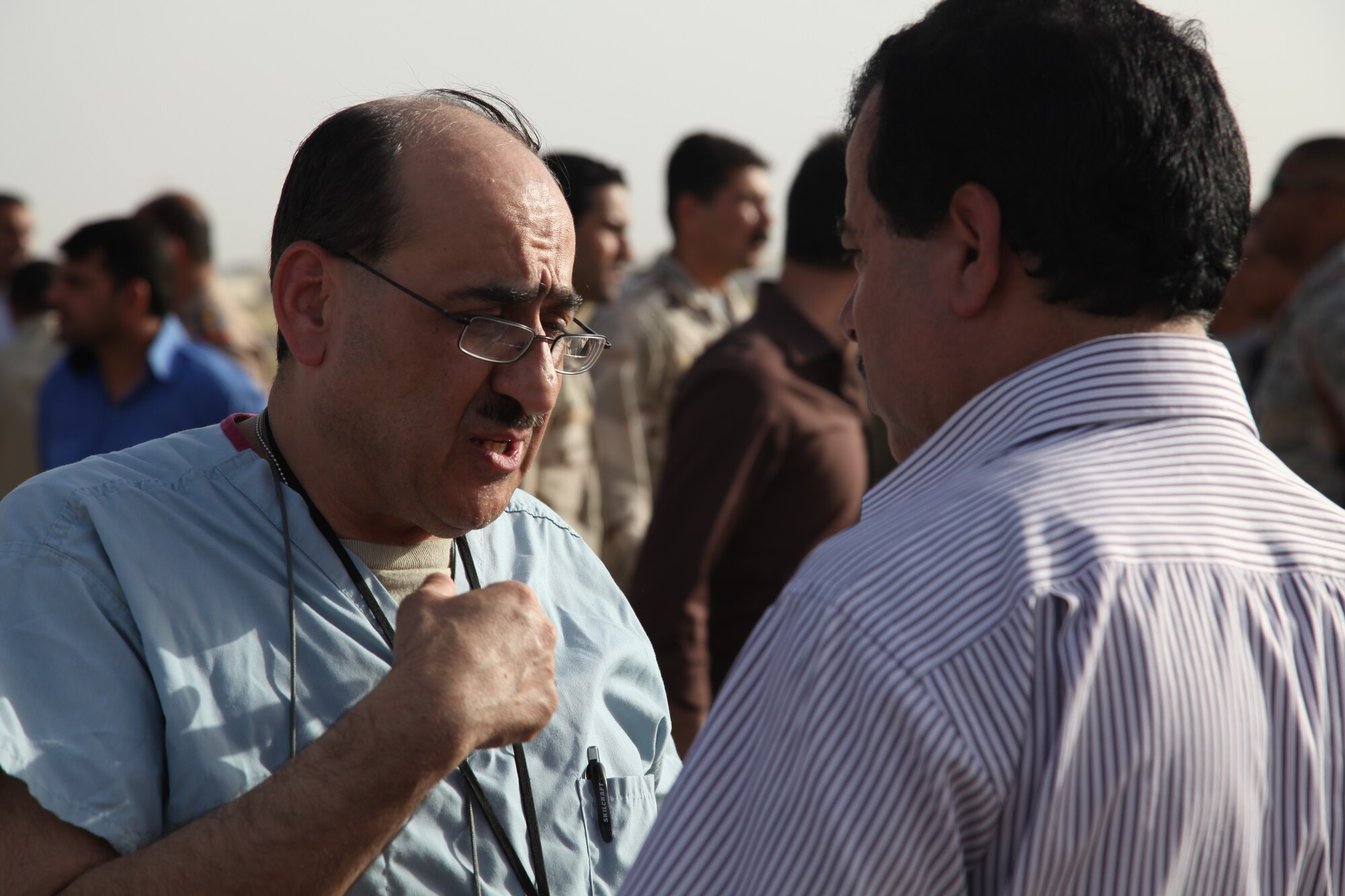 KIRKUK REGIONAL AIR BASE, Iraq – Col. Nabil Habib, 321st Expeditionary Medical Squadron general surgeon, left, discusses long-term care concerns with a family member of a victim of improvised explosive devices which detonated near the police station in Kirkuk May 19. Reports indicate 20 people were killed and nearly 80 people were injured. The 321st EMEDS coordinated medical airlift to Turkey when the patients were stable enough to move. (Courtesy photo)