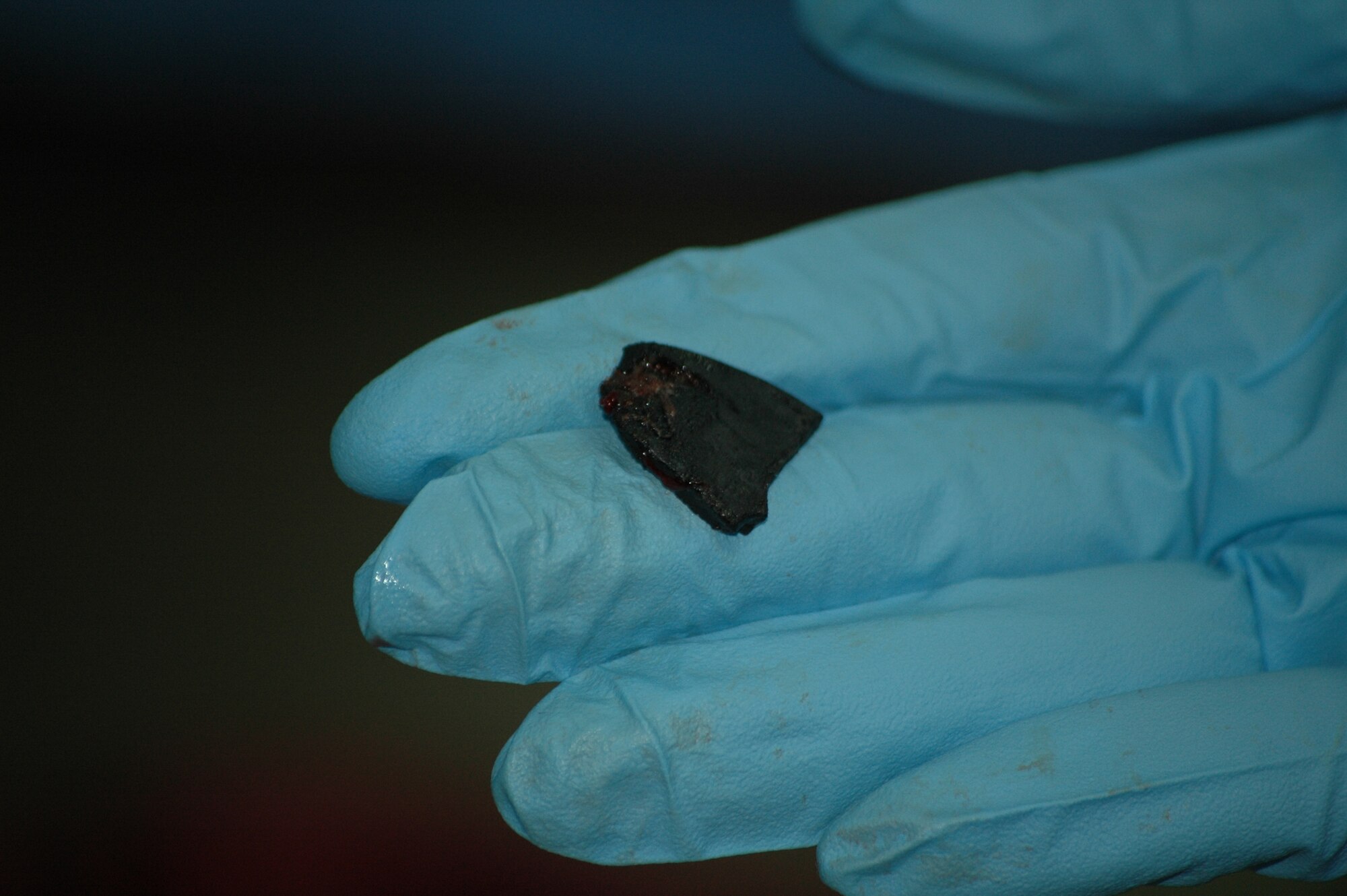 KIRKUK REGIONAL AIR BASE, Iraq – A surgeon with the 321st Expeditionary Medical Squadron shows off a piece of shrapnel pulled from a a civilian patient brought to the base hospital May 19. Reports indicate 20 people were killed and nearly 80 people were injured when improvised explosive devices detonated near the police station in Kirkuk. The 321st EMEDS volunteered to help care for the wounded when civilian facilities were overwhelmed. (Courtesy photo)