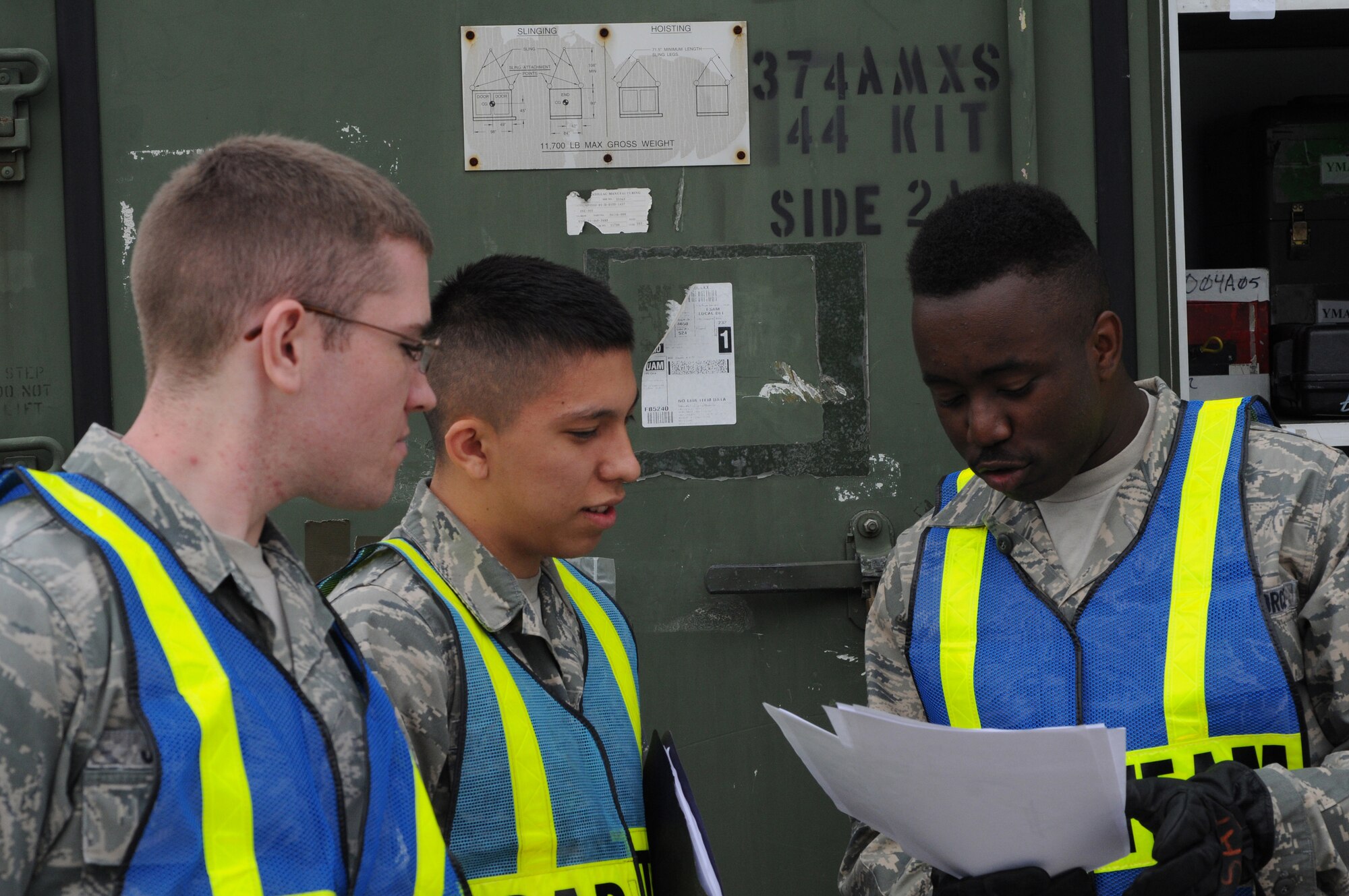 YOKOTA AIR BASE, Japan -- (right to left) Airman 1st Class Jarrett Hunt, Airman 1st Class Isaac Perez and Airman Brendon Johnson, 374th Maintenance Squadron aerospace propulsion apprentices, check documents June 8, 2011, during a readiness exercise at Yokota Air Base, Japan. The goal of the exercise was to test Yokota's ability to respond appropriately and effectively to real world contingencies. (U.S. Air Force photo/Airman John D. Partlow)