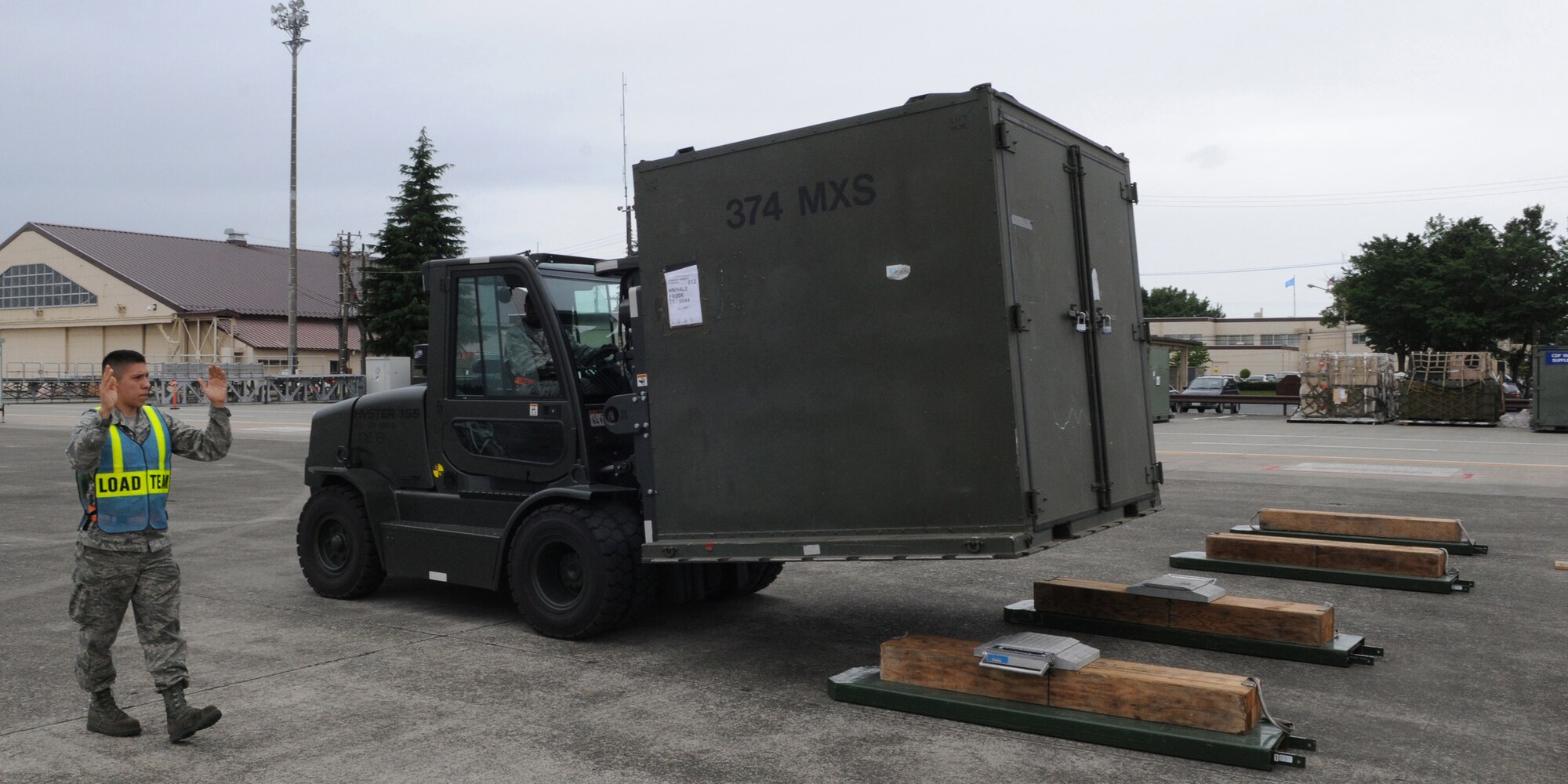 YOKOTA AIR BASE, Japan -- Airman 1st Class Isaac Perez, 374th Maintenance Squadron aerospace propulsion apprentice, directs Tech. Sgt. Thomas Greer, 374th Logistics Readiness Squadron NCO in charge of storage supply, as he drives equipment via forklift to digital weighing scales June 8, 2011, during a readiness exercise at Yokota Air Base, Japan. The equipment is weighed to ensure it can be properly stored. (U.S. Air Force photo/Airman John D. Partlow)