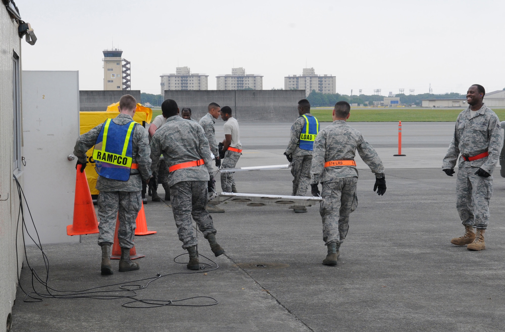 YOKOTA AIR BASE, Japan -- Members of the 374th Maintenance Squadron and the 374th Logistics Readiness Squadron carry digital weighing scales June 8, 2011, during a readiness exercise at Yokota Air Base, Japan. The scales are used to weigh equipment to ensure they are stored properly. (U.S. Air Force photo/Airman John D. Partlow)