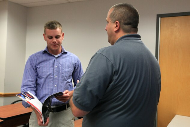 Paul Plunkett, an employee of Wyotech, gives a service member a brochure outlining paths he can take following the end of his enlistment after a Transition Assistance program workshop at Joint Base Myer-Henderson Hall, Va., June 9, 2011. The Transition Assistance Program aids Marines in selecting a plan for their transition into the civilian world.