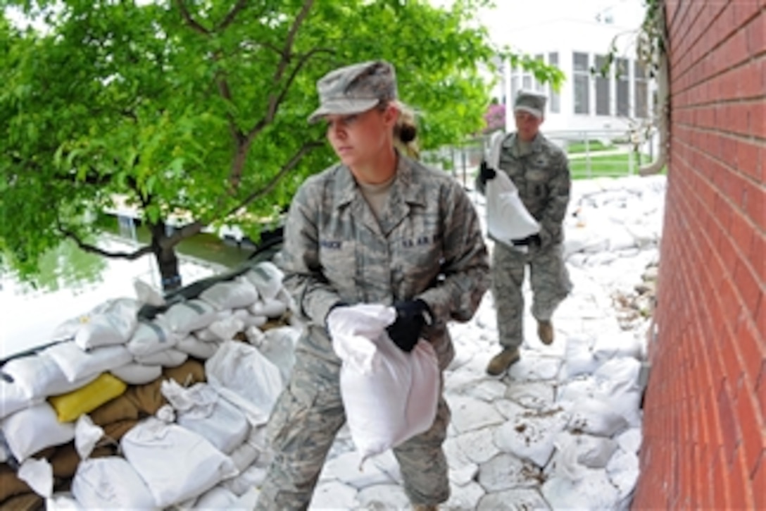 U.S. Air Force Senior Airman Tracy Mauch (left), with the North Dakota Air National Guard's 119th Logistics Readiness Squadron, and Tech. Sgt. Brad Schenck, with the 119th Wing's Security Forces Squadron, place sandbags alongside a home along the Missouri River in Bismarck, N.D., on June 2, 2011.  More than 1,300 North Dakota National Guard members were working on flood duty in the Bismarck and Mandan communities to prepare for a rapid rise in the Missouri River that runs between the two communities.  