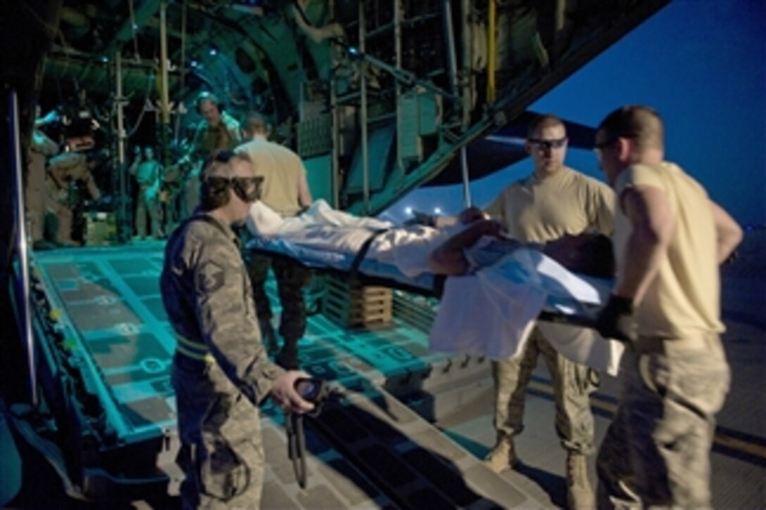 Members of the 451st Expeditionary Aeromedical Evacuation Squadron load a wounded Marine onto a C-130 Hercules aircraft at Camp Bastion, Afghanistan, on May 21, 2011.  