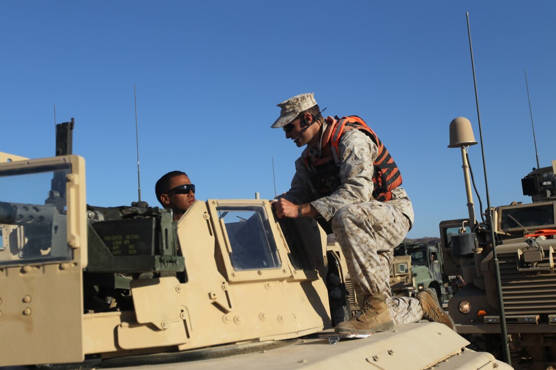 A gunner with Marine Wing Support Squadron 371, talks with an instructor before conducting the convoy training for Enhanced Mojave Viper at range 205 June 10, 2011.::r::::n::
