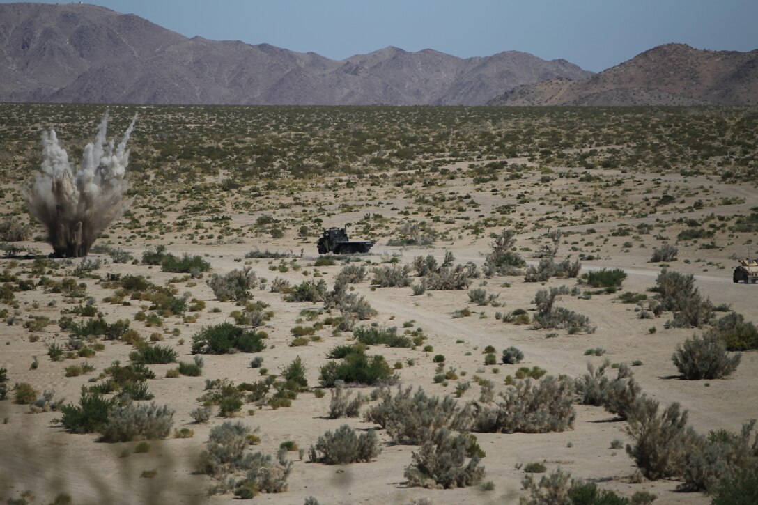 A simulated improvised explosive device detonates as a vehicle with Motor Transportation Co., Marine Wing Support Squadron 371, approaches during Enhanced Mojave Viper convoy training at range 205 June 10, 2011.::r::::n::