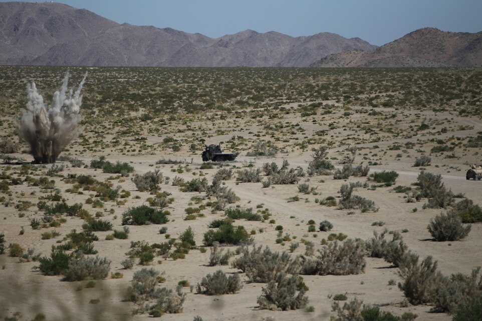 A simulated improvised explosive device detonates as a vehicle with Motor Transportation Co., Marine Wing Support Squadron 371, approaches during Enhanced Mojave Viper convoy training at range 205 June 10, 2011.::r::::n::