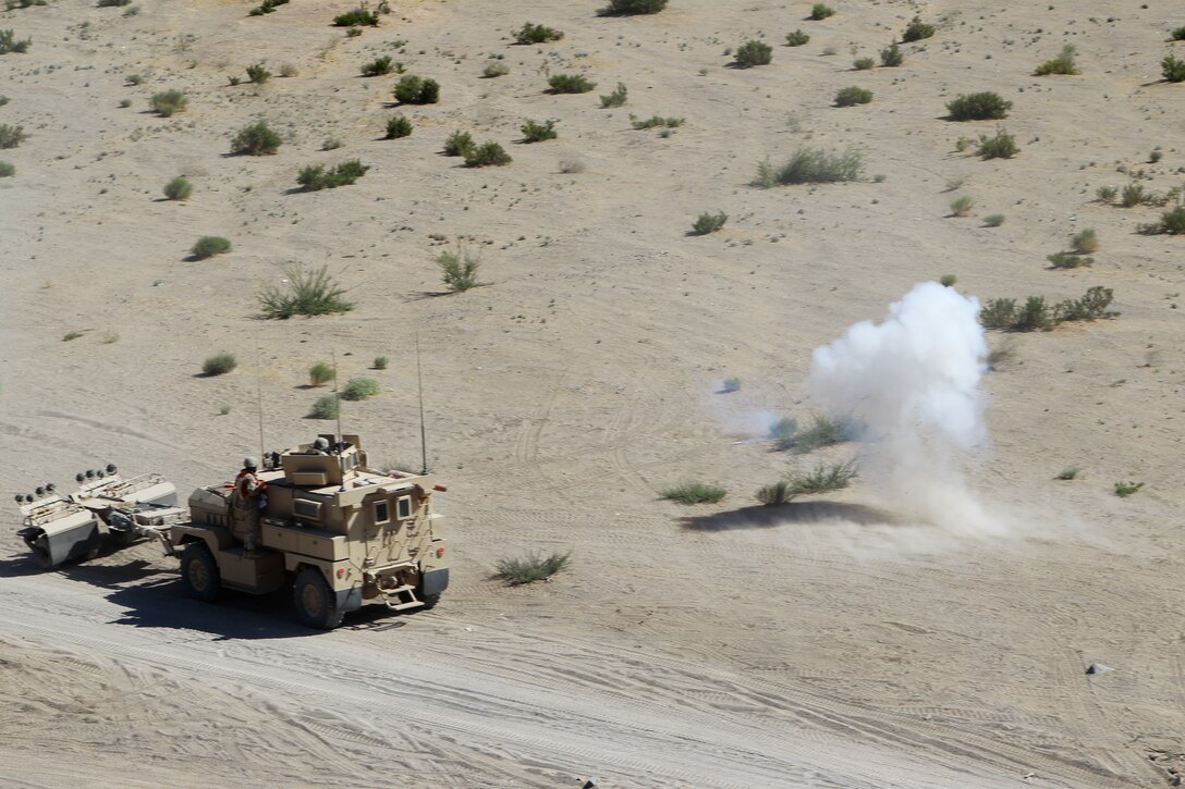 Simulated mortar rounds add a sense of danger as the Marines and sailors of Motor Transportation Co., Marine Wing Support Squadron 371, engage in a simulated fire fight during the Enhanced Mojave Viper convoy training at Combat Center range 205 June 10, 2011.