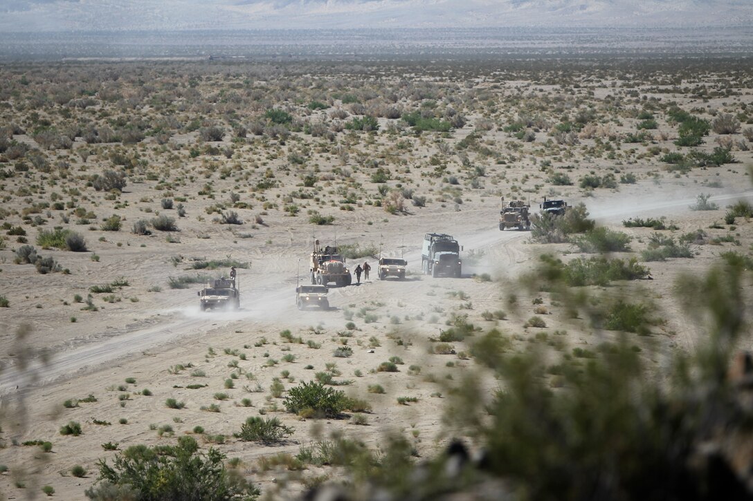 Unarmed vehicles with Motor Transportation Company, Marine Wing Support Squadron 371, wait for the engagement to end before pushing through the hot zone and continuing on to the convoy’s destination during Enhanced Mojave Viper convoy training at Combat Center range 205 June 10, 2011.