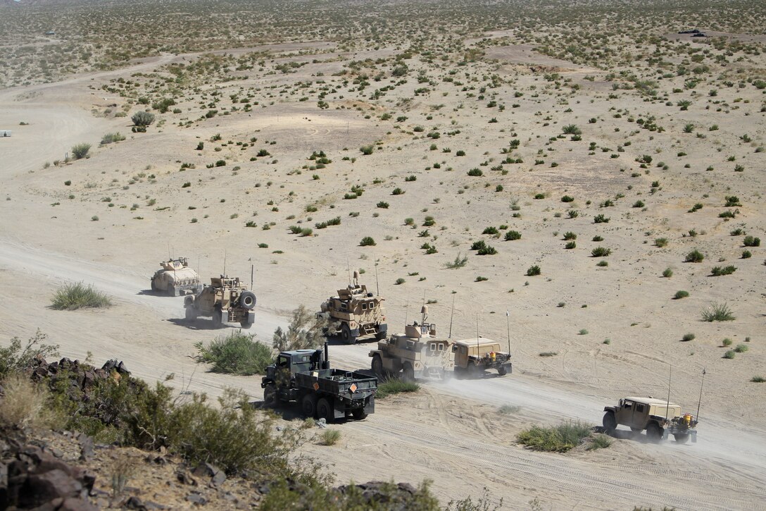 Convoy vehicles with Motor Transportation Company, Marine Wing Support Squadron 371, rush through a hot zone before forming back up and continuing to their destination during Enhanced Mojave Viper convoy training at Combat Center range 205 June 10, 2011.