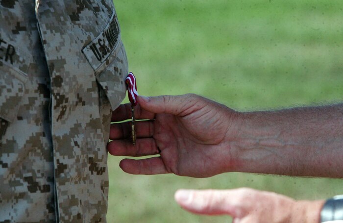 Master Gunnery Sgt. Brian Daneker is awarded the Meritorious Service Medal during his retirement ceremony at W.P.T. Hill Field aboard Camp Lejeune, N.C., June 10, 2011. After 30 years of service to his country, Daneker will retire in Swansboro, N.C., with his wife. (U.S. Marine Corps photo by Pfc. Franklin E. Mercado)