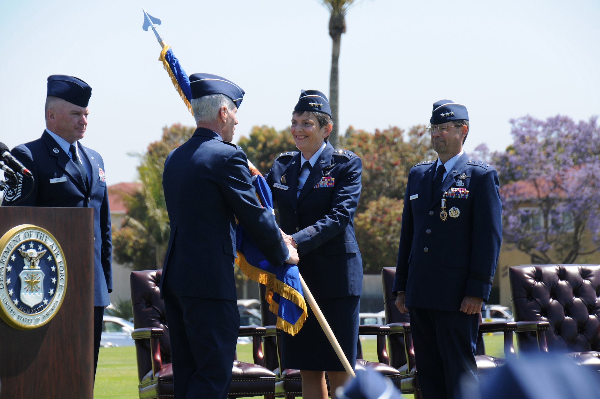 Lieutenant Gen. Ellen Pawlikowski, the first female Space and Missile System Center commander, accepts the command flag from Air Force Space Command commander, Gen. William Shelton, as SMC Command Chief Master Sgt. Mark Repp (far left) and outgoing SMC commander, Lt. Gen. Tom Sheridan (far right) look on.  General Shelton officiated the change of command ceremony held on Fort MacArthur's parade grounds, June 3. (Photo by Joe Juarez)