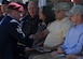 Staff Sgt. Lucas Ferrari, a pararescueman from the 48th Rescue Squadron, shakes the hand of Anthony White, father of Senior Airman Benjamin White, and presents him with a ceremonial street sign with Airman White’s name on it at Davis-Monthan Air Force Base, Ariz., June 9, 2011. Tech. Sgt. Michael Flores and Senior Airman Benjamin White, pararescuemen from the 48th RQS, were killed in the Pedro 66 crash in Afghanistan June 9, 2010. (U.S. Air Force photo by Senior Airman Brittany Dowdle/Released)