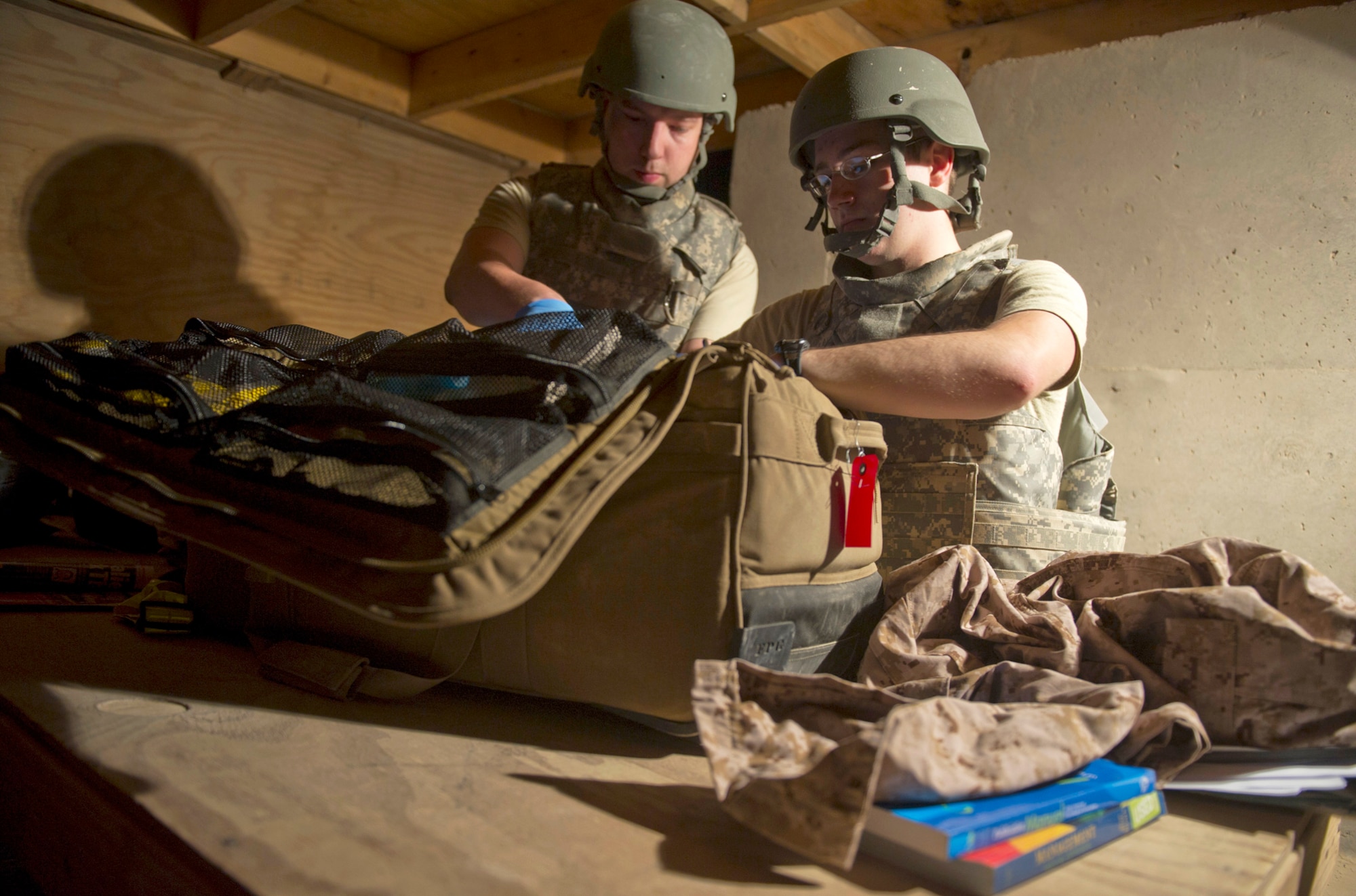 Senior Airman Cyril McKenney (left) and Airman 1st Class Dennis Nellessen search a patient's bag May 26, 2011, during an anti-hijacking check prior to loading patients onto an aircraft at the contingency aeromedical staging facility at Camp Bastion, Afghanistan. Airman McKenney and Airman Nellessen are aerospace medical technicians assigned to the 451st Expeditionary Aeromedical Evacuation Squadron. (U.S. Air Force photo/Master Sgt. Adrian Cadiz)