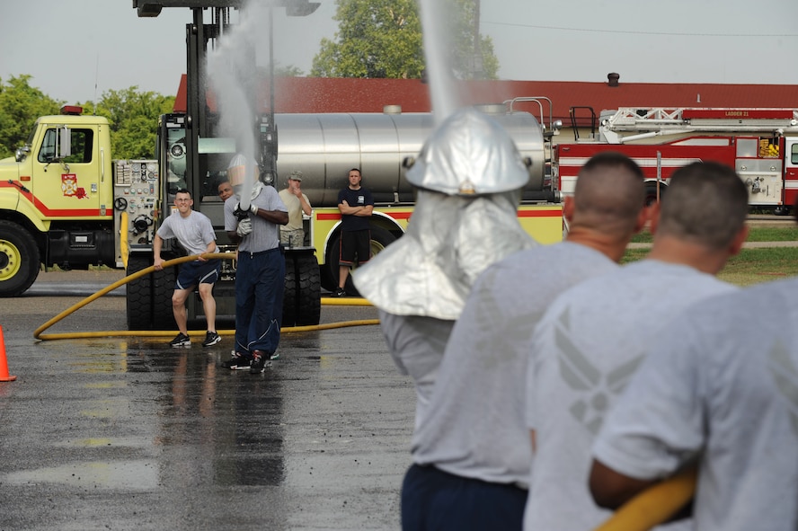 Airmen from the 2nd Force Support Squadron battle against Airmen from the 2nd Civil Engineer Squadron during the hose joust for the third annual Fire Muster on Barksdale Air Force Base, La., June 10. The members from each squadron must use a fire hose to spray a target to the opposite side. Fire Musters are held for friendly competition, boost morale and to display firefighter craftsmanship. (U.S. Air Force photo/Airman 1st Class Micaiah Anthony)(RELEASED)