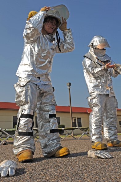 Airmen from the 2nd Contracting Squadron don fire-protective gear during the midnight alarm event for the third annual Fire Muster on Barksdale Air Force Base, La., June 10. The midnight alarm event simulates lying in bed at night when the alarm goes off. Participants have to get out of their cots and don the full firefighter ensemble. By regulation, firefighters have 60 seconds to be completely dressed and headed out of the station. (U.S. Air Force photo/Airman 1st Class Micaiah Anthony)(RELEASED)
