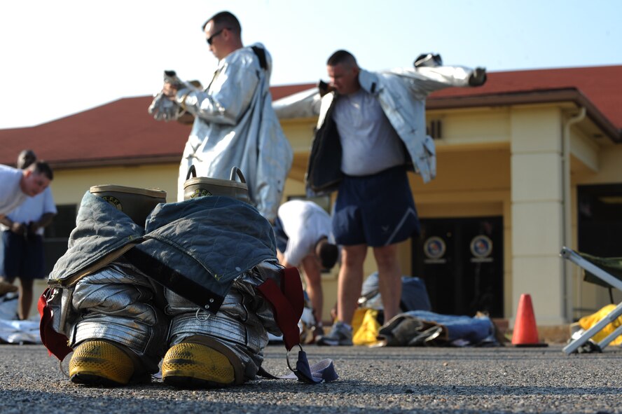 Airmen from the 2nd Communications Squadron don fire protection gear during the third annual Fire Muster on Barksdale Air Force Base, La., June 10. The 2 CS, 2nd Force Support Squadron, 2nd Civil Engineer Squadron and 2nd Contracting Squadron competed against each other during the event. Fire musters are held for friendly competition, boost morale and to display firefighter craftsmanship. (U.S. Air Force photo/Airman 1st Class Micaiah Anthony)(RELEASED)