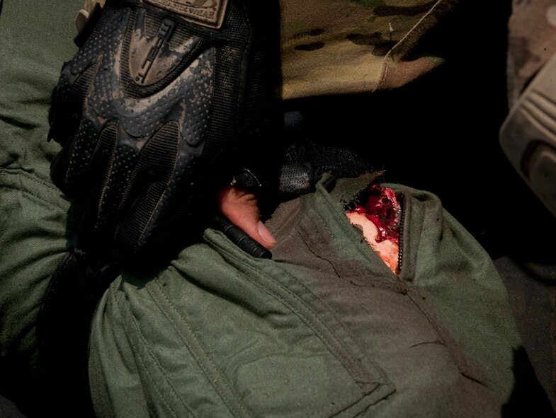 A U.S. Air Force pararescueman assigned to the 38th Rescue Squadron applies a tourniquet to a simulated patient’s leg during a medical evacuation exercise June 9 at Moody Air Force Base, Ga.  Moulage and artificial injuries were placed on patients to make the training as realistic as possible for the pararescuemen. (U.S. Air Force photo by Airman 1st Class Nicholas Benroth/Released) 