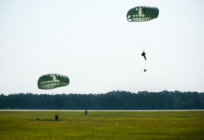 Two U.S. Air Force pararescuemen assigned to the 38th Rescue Squadron land during a medical evacuation exercise June 9 at Moody Air Force Base, Ga. The pararescuemen performed a static line jump and a free fall jump to remain current on training for an upcoming deployment. (U.S. Air Force photo by Senior Airman Benjamin Wiseman/Released)