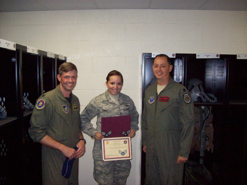 Airman 1st Class Madeline Conley, 2nd Operations Support Squadron life support specialist, is presented with her new stripes from Lt. Col. Frederick Frostic, 36th Operations Support Squadron Commander, and Lt. Col. John Edwards, 96th Expeditionary Bomb Squadron commander, at Andersen Air Force Base, Guam. Airman Conley was selected below the zone for promotion to senior airman. She is currently deployed from Barksdale Air Force Base, La., to Andersen AFB in support of the continuous bomber presence mission. (U.S. Air Force photo/Tech. Sgt. Chris Scott)(RELEASED)