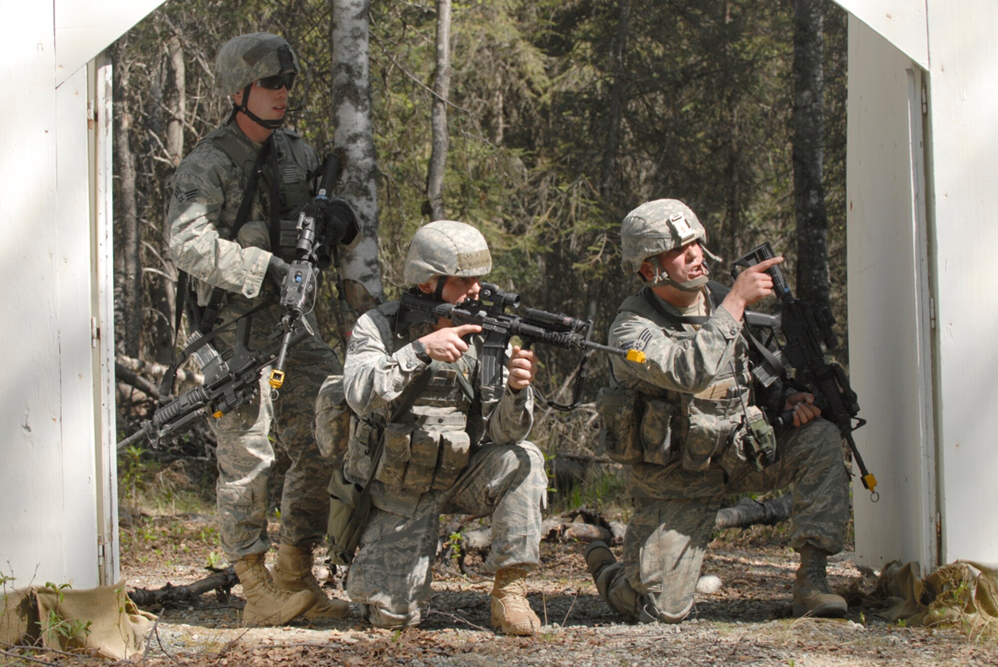 Senior Airman Payton Barnes, Airman 1st Class Stephen Becker and Air Force Staff Sgt. John Szewzyk, 673d Security Forces Squadron, come under simulated fire during a village sweep as part of Polar Force 11-5 which tested readiness for Joint Base Elmendorf-Richardson agencies, May 23-25. (U.S. Air Force photo/Steve White)