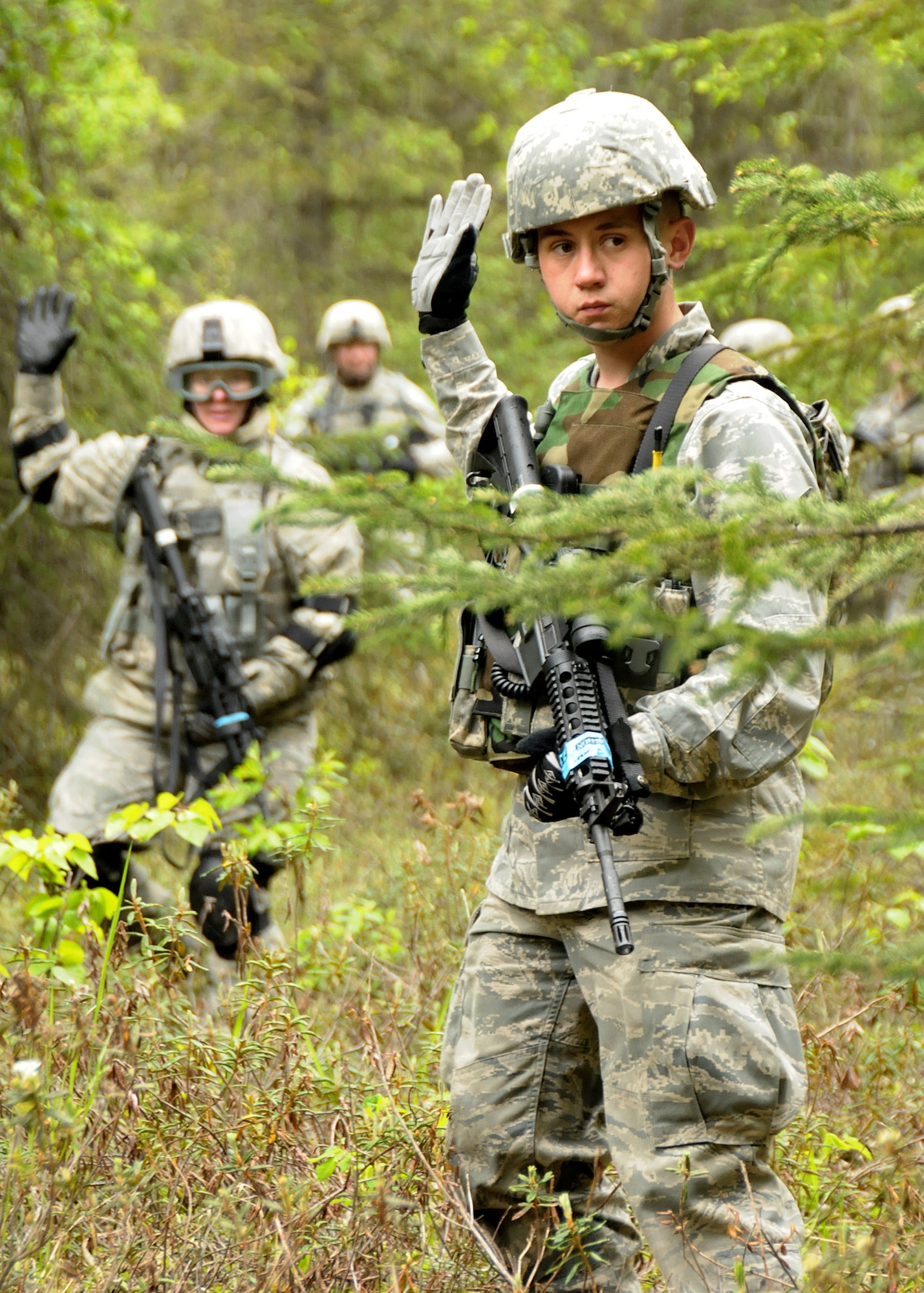 Senior Airman Justin Cookson from the 146th Airlift Wing Security Force Squadron, Channel Islands Air National Guard Station, Calif. uses hand signals to relay commands to other members during a practice patrol exercise in the woods at Joint Base Elmendorf-Richardson, Anchorage, Alaska.  (Photo by Tech. Sgt. Alex Koenig)