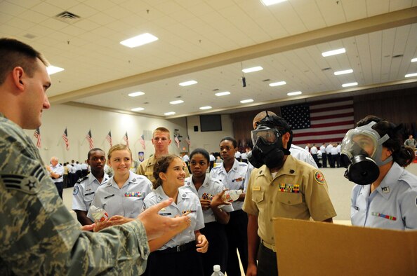 Senior Airman Brandon Ashcraft, 2nd Civil Engineer Squadron, briefs Junior Reserve Officer Training Corps cadets on gas masks use during the JROTC career day at Hoban Hall on Barksdale Air Force Base, La., June 9. Tables, representing various careers, lined the hall as cadets rotated around the room talking with career field experts and getting hands-on experience with Air Force equipment. (U.S. Air Force photo/Senior Airman Joanna M. Kresge)