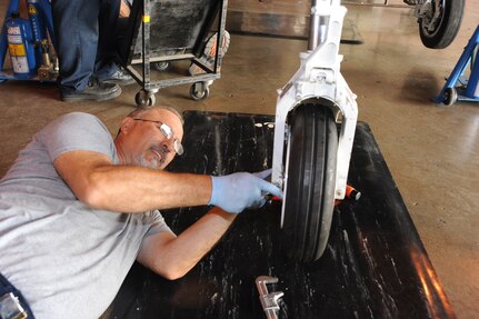 Enrique Rodriguez, 12th Flying Training Wing aircraft maintenance, adjusts the front wheel of a T-6 Texan II aircraft during a phase inspection June 7 at Randolph Air Force Base.  (U.S. Air Force photo/Rich McFadden) (released)