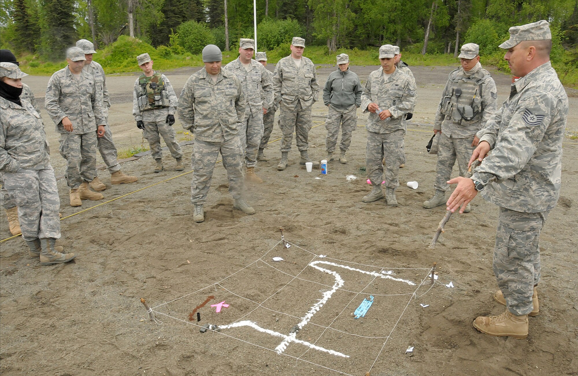 Tech. Sgt. Marco De La Cruz, a member of the 146th Security Force Squadron, 146th Airlift Wing, Channel Islands Air National Guard Station, Calif. uses a sand table, a three-dimensional version of a grid map, to illustrate how maps are a vital aid when traversing rough torrain as well as obtaining intelligence on a possible target. Security Force Squadron members from the 146 AW practiced patrol tactics in the woods at Joint Base Elmendorf-Richardson, Anchorage, Alaska June 2011. (Photo by Tech. Sgt. Alex Kolb)