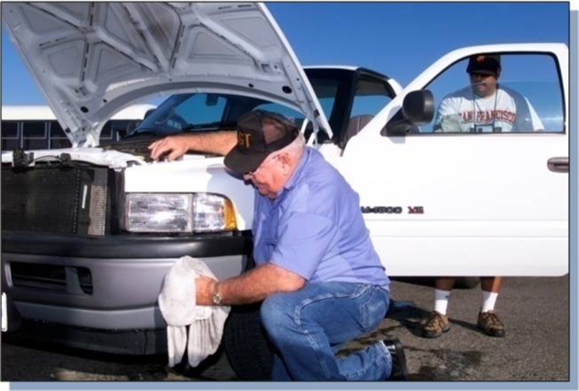 John Ogao, at window, and Marvin Bridges, at bumper, 60th Logistics Readiness Squadron motor vehicle operator, clean and inspect a vehicle. (Courtesy photo/ Nick Dyson)