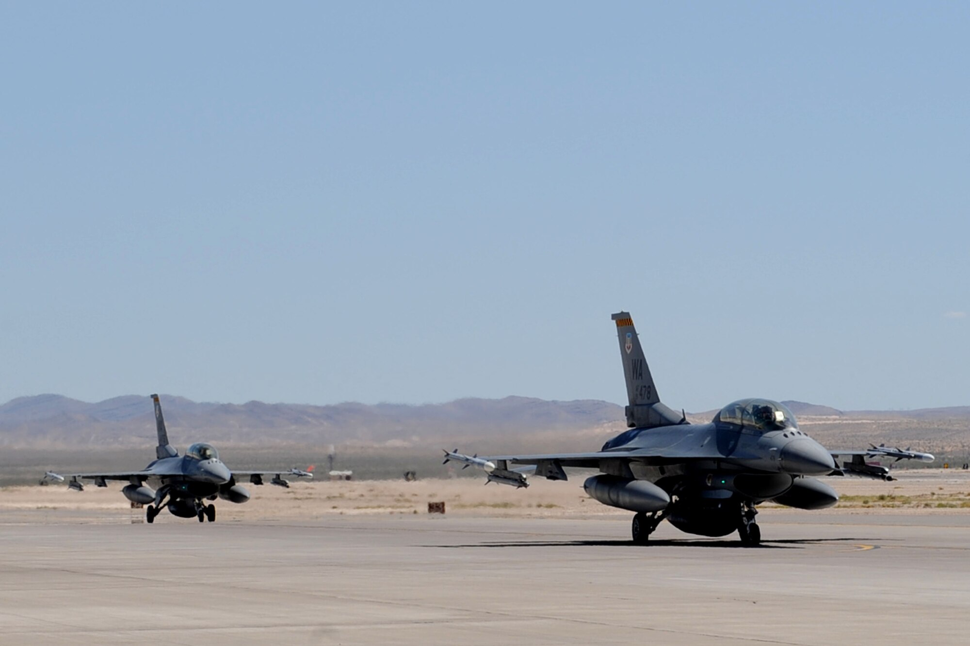NELLIS AIR FORCE BASE, Nev.-- A two-ship of F-16 Fighting Falcons assigned the U.S. Air Force Weapons School taxi out to the Nellis flightline during the Mission Employment phase, June 8, 2011. More than 5,000 personnel are involved in the final phase of the Weapons School graduate course, resulting in 89 students from 21 separate combat specialties graduating as U.S. Air Force Weapons Officers.(U.S. Air Force photo by Staff Sgt. Taylor Worley)
