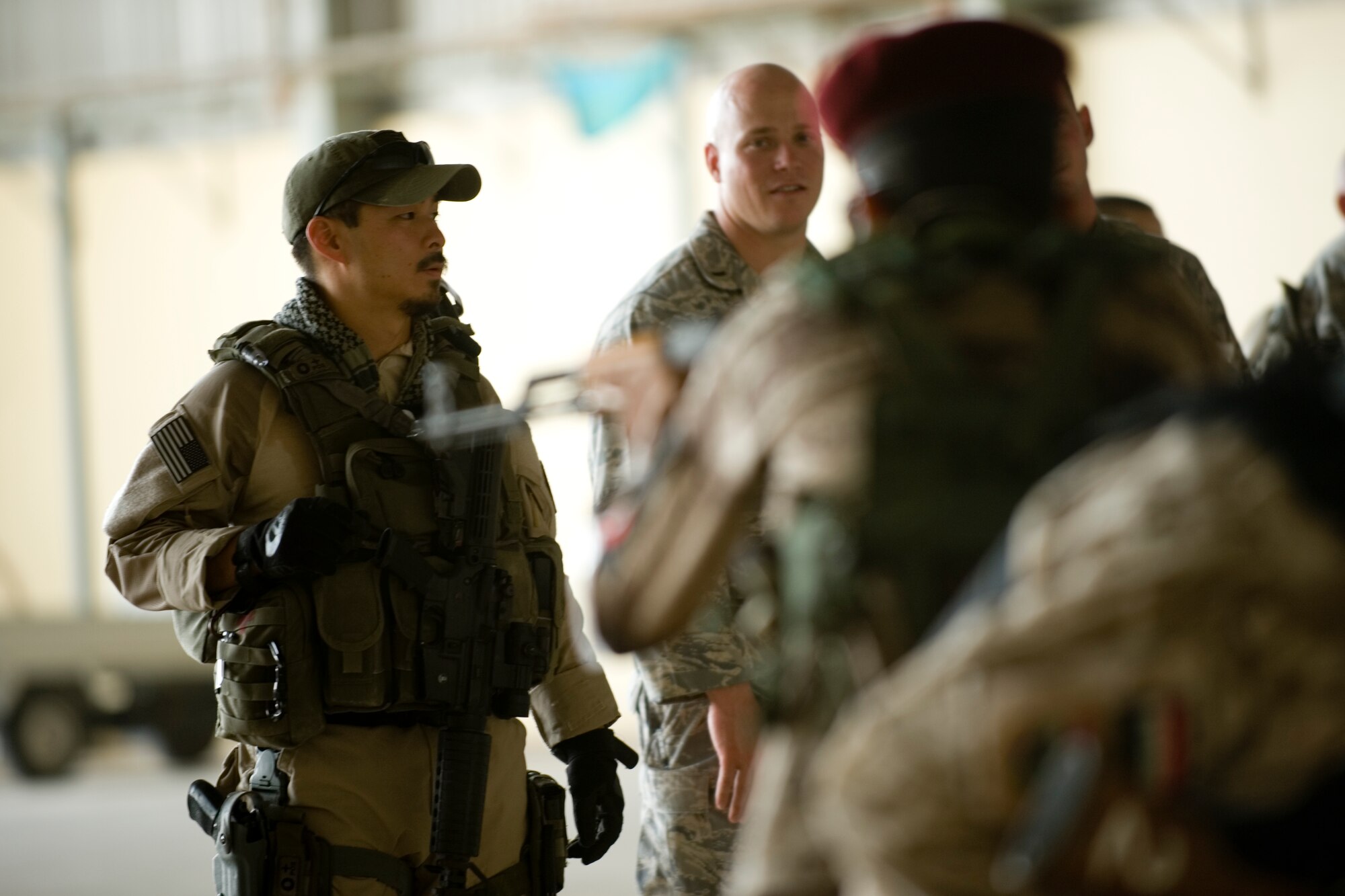 Special Agent Masashi Yamazaki (left), instructs Iraqi security forces members on personal security operations at New Al Muthana Air Base, Iraq, June 1. The Iraqis were participating in personal security operations training to develop the skills needed to protect their leaders in future operations. (U.S. Air Force photo/Staff Sgt. Levi Riendeau)