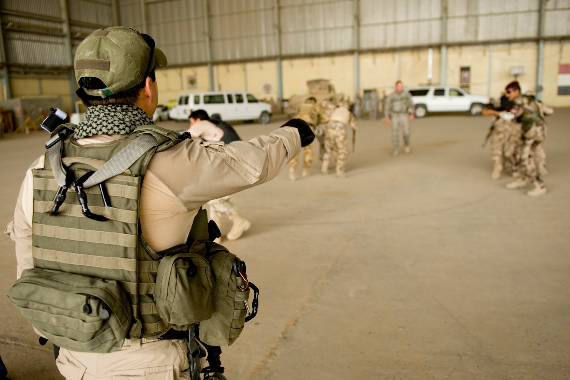 Special Agent Masashi Yamazaki (left) instructs Iraqi security forces members on personal security operations at New Al Muthana Air Base, Iraq, June 1. The Iraqis were participating in personal security operations training to develop the skills needed to protect their leaders in future operations. (U.S. Air Force photo/Staff Sgt. Levi Riendeau)