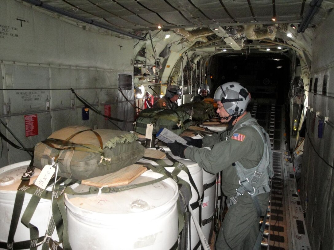 Master Sgt. James Courneya, 96th Airlift Squadron loadmaster, reviews data for an Improved Container Delivery System airdrop over the Arnold Drop Zone at Camp Ripley, Minn. June 9. (Air Force photo/Wendy Cormier) 