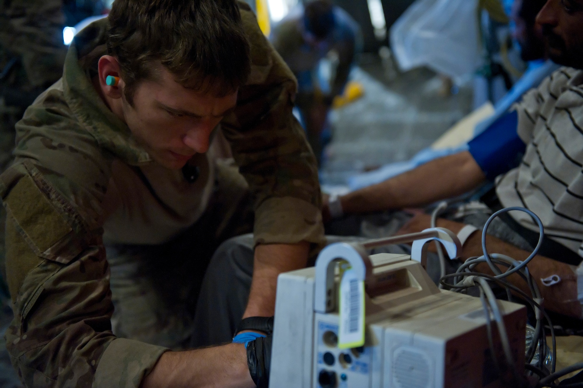 Senior Airman Steve Reibitz, 46th Expeditionary Rescue Squadron pararescuemen, reads the vital signs of a wounded Afghan national as he takes the patients blood pressure on an HC-130P Hercules assigned to the 76th ERQS during a casualty evacuation mission. Members of the 46th and 76th ERQS are responsible for conducting combat search and rescue as well as personnel recovery missions in Afghanistan and assist with CASEVAC missions when available. (U.S. Air Force photo/Master Sgt. Adrian Cadiz)