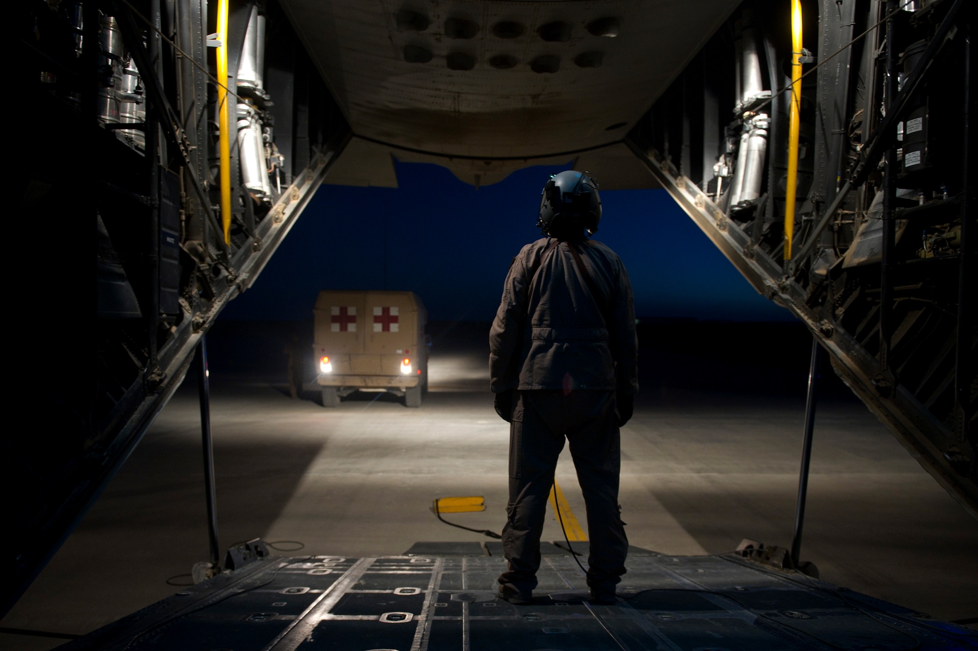 Staff Sgt. Mary Sierra, 76th Expeditionary Rescue Squadron loadmaster, prepares to help back an ambulance carrying a wounded Afghan National Security Force member into place in order to load the patient onto an HC-130P Hercules for a casualty evacuation mission. Members of the 76th ERQS are responsible for conducting combat search and rescue as well as personnel recovery missions in Afghanistan and assist with CASEVAC missions when available. (U.S. Air Force photo/Master Sgt. Adrian Cadiz)
