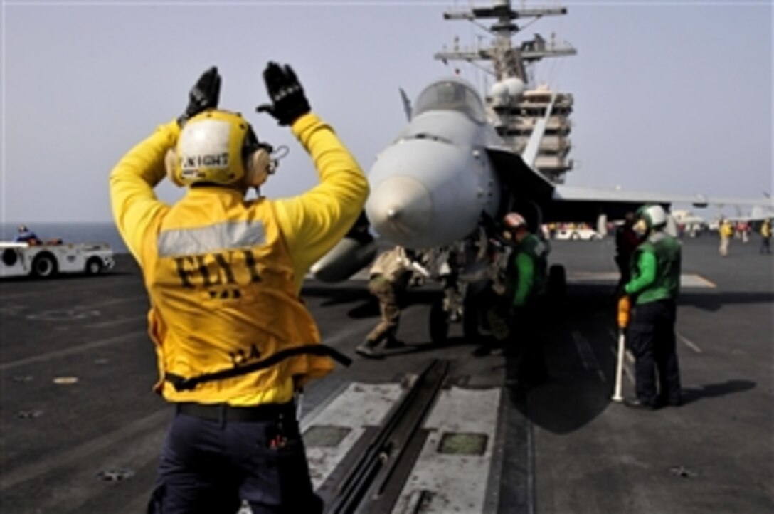 Petty Officer 3rd Class Patrick Wight signals to the pilots of an F/A-18 aircraft before launching off the flight deck of the aircraft carrier USS Ronald Reagan (CVN 76) in the Arabian Sea on June 6, 2011.  The Ronald Reagan and Carrier Air Wing 14 are deployed to the U.S. 5th Fleet area of responsibility conducting close-air support missions as part of Operation Enduring Freedom.  