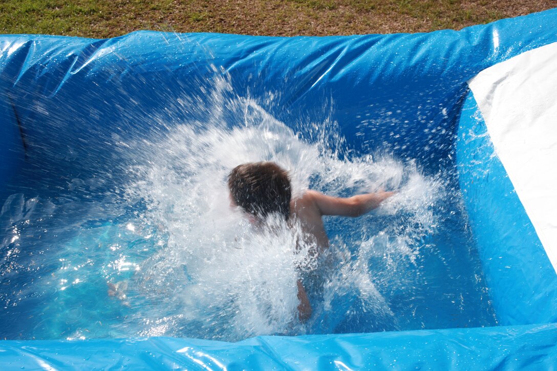 The cookout for the 101 Days of Summer Drug and Alcohol-Free Challenge held at Afterburners provided participants with hamburgers and hot dogs, billiards, air hockey, ladder golf, corn hole, horseshoes and volleyball. The main attraction, however, was the water slide. The attendees took turns cooling off.::r::::n::