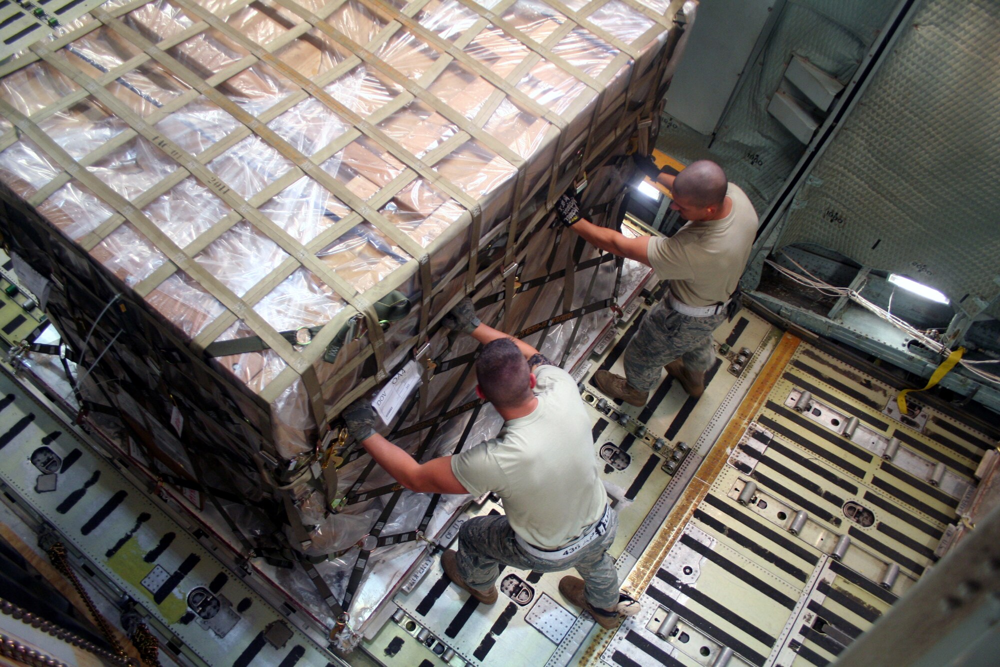 Airmen 1st Class Dustin Carlton and Brett Kiser, air transportation journeymen from the 436th Aircraft Aerial Port Squadron, check on cargo on a C-5M Super Galaxy on June 5, 2011, prior to the plane's departure for a direct delivery airlift mission through the Arctic Circle from Dover Air Force Base, Del., to Bagram Airfield, Afghanistan. (U.S. Air Force Photo/Master Sgt. Scott T. Sturkol)