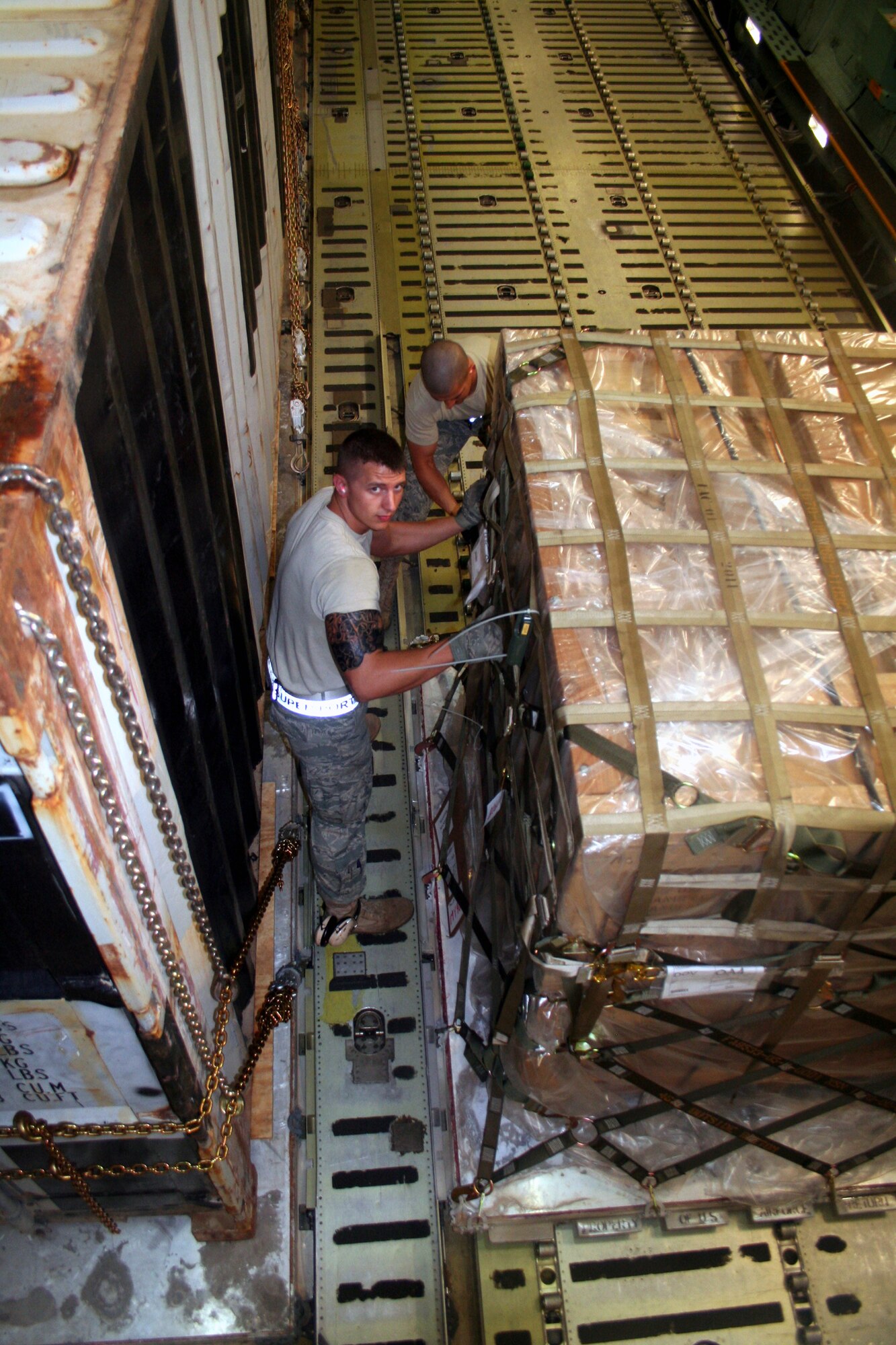 Airmen 1st Class Dustin Carlton and Brett Kiser, air transportation journeymen from the 436th Aircraft Aerial Port Squadron, check on cargo on a C-5M Super Galaxy on June 5, 2011, prior to the plane's departure for a direct delivery airlift mission through the Arctic Circle from Dover Air Force Base, Del., to Bagram Airfield, Afghanistan. (U.S. Air Force Photo/Master Sgt. Scott T. Sturkol)