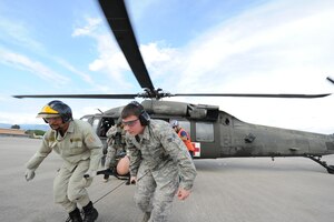 Ruben Barahona, a Honduran firefighter, and Senior Airmen Christopher Benner, 612th Air Base Squadron firefighter, carry away a life-sized 175-pound "victim” from a UH60 helicopter during an exercise June 7, 2011 at Soto Cano Air Base, Honduras. The exercise, called Central America Sharing Mutual Operational Knowledge and Experiences, or CENTAM SMOKE, allows U.S. and Honduran Airmen and civilian firefighters four days of team-building training.   