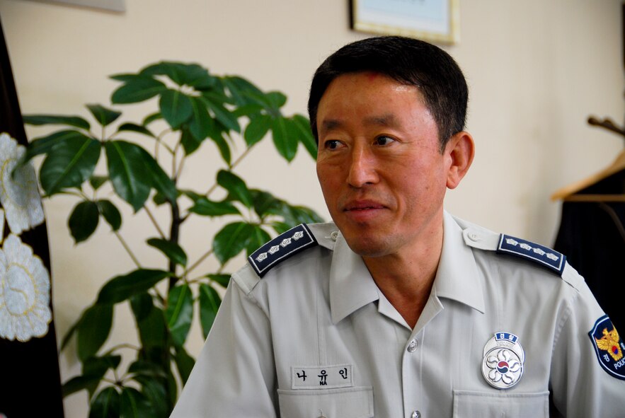 GUNSAN CITY, Republic of Korea -- Chief Na Yu-In, Gunsan City Korean National Police chief, enjoyed the presentation by Lt. Col. Mark Anarumo, 8th Security Forces Squadron commander, on the routine activity theory here June 7. “It sounds like a pretty good theory,” he said. (U.S. Air Force photo/1st Lt. Trisha Eldredge)